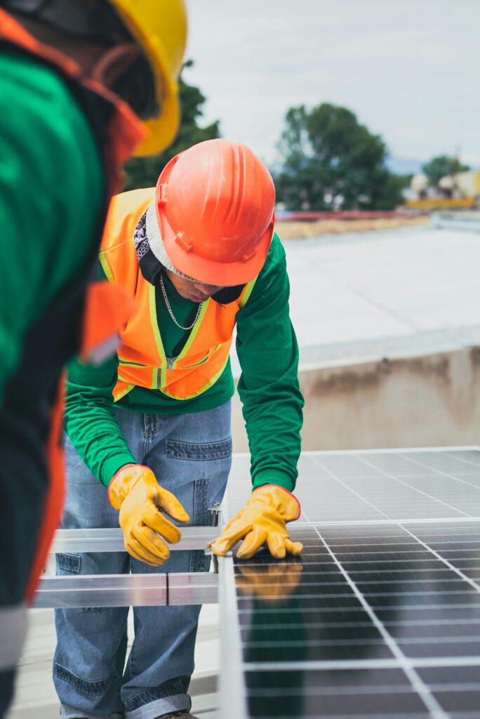 pexels photo 8853507 8853507 Worker in safety gear installing solar panels on a rooftop.